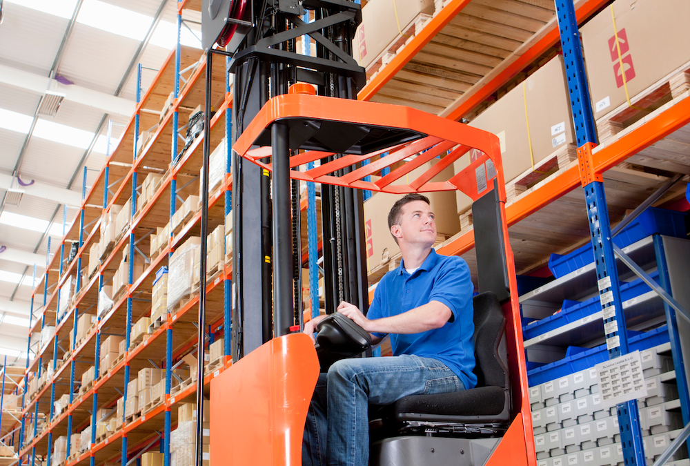 Man driving a forklift in a warehouse.