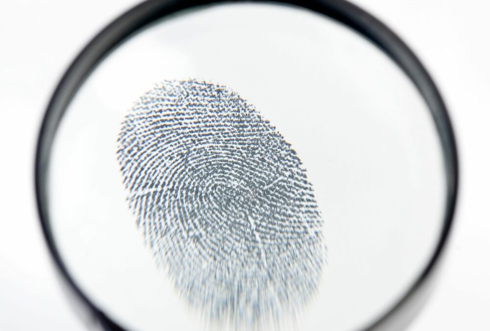 Magnifying glass looking at fingerprint.